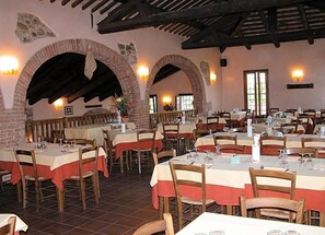 An indoor dining area with brick arches, wooden tables, and chairs. - Da Nicola (Montegrotto Terme)