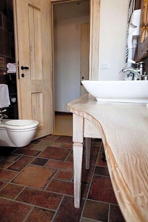 A bathroom with a white sink, a white toilet, and a wooden door. - Garnv La Rua Nel Bosco (Rivisondoli)