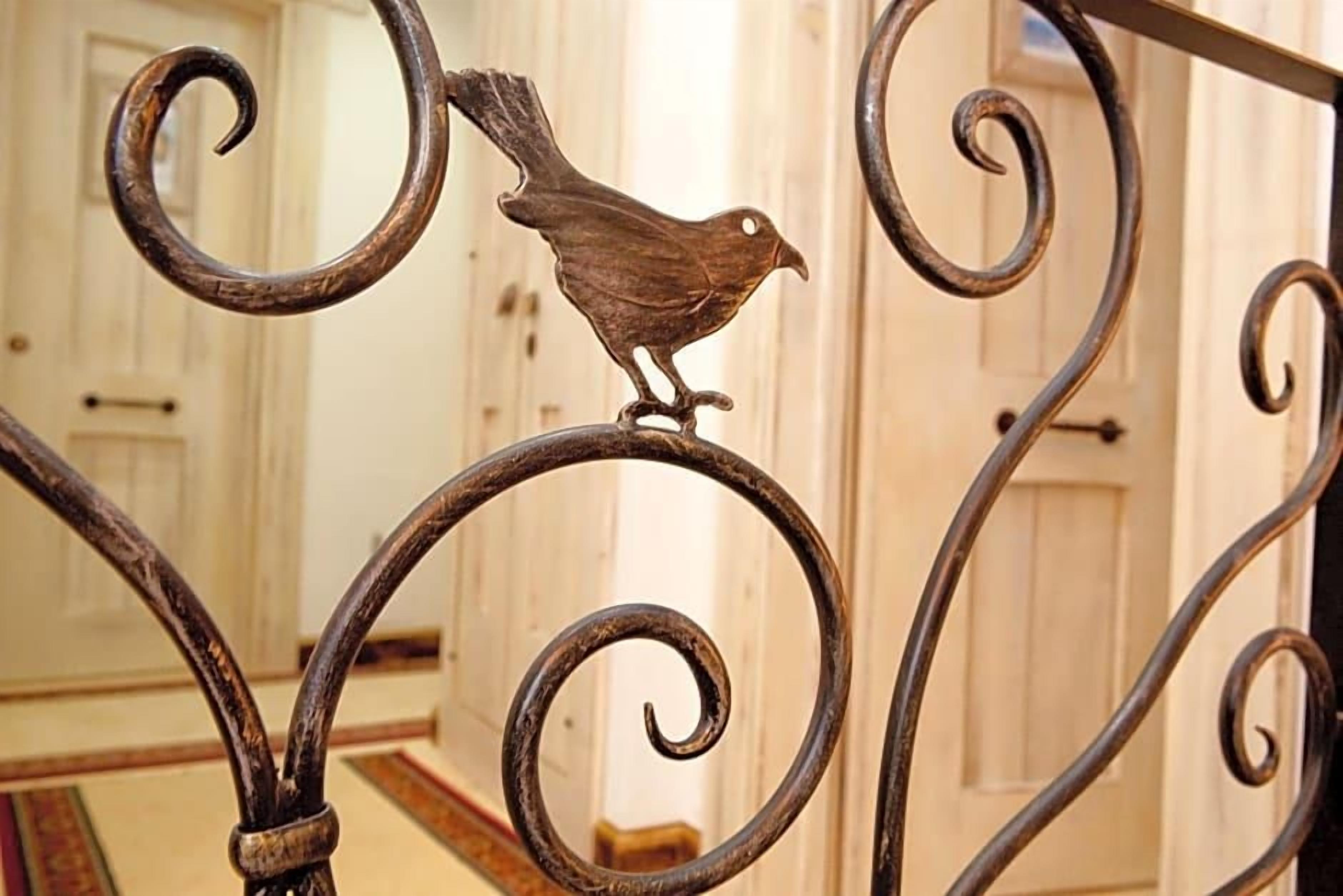 Ein schmiedeeiserner Geländer mit einer Vogelfigur.