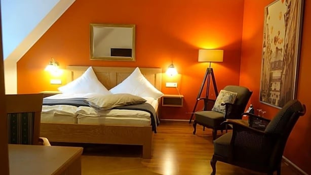 A bedroom with a bed, bedside lamps, a chair, a desk, and a painting on the wall. - Hotel Restaurant Venner Moor (Senden)