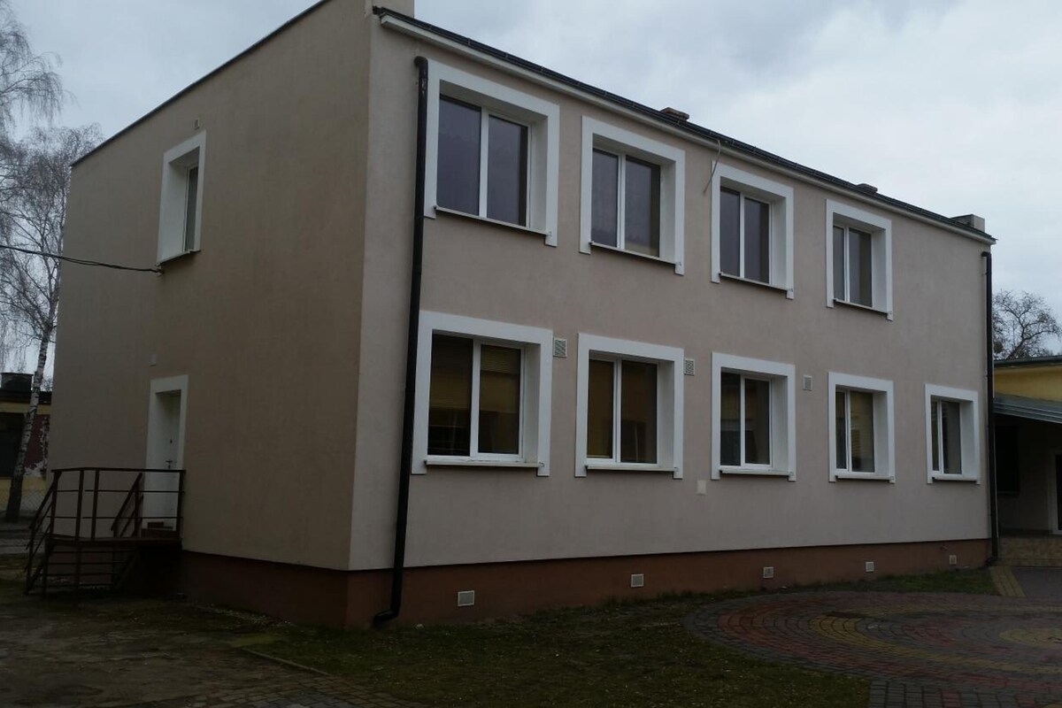 A two-story building with a flat roof and multiple windows.