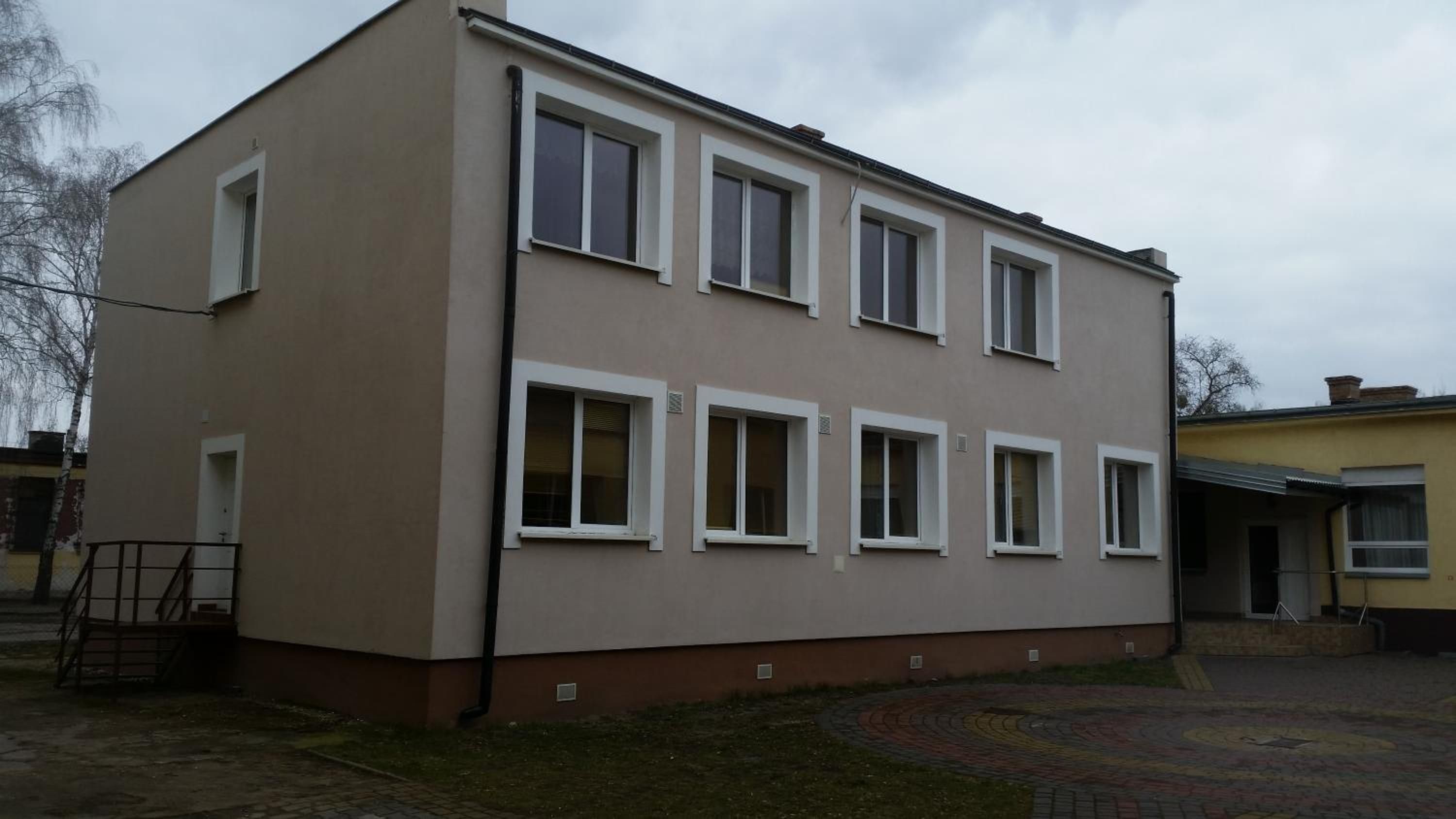 A two-story building with a flat roof and multiple windows.