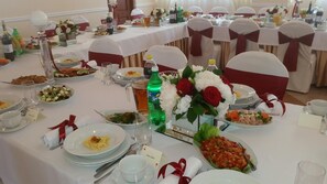 A banquet table set with various dishes, glasses, and a bottle of Sprite. - Hotel Go Ociniec (Wloclawek)