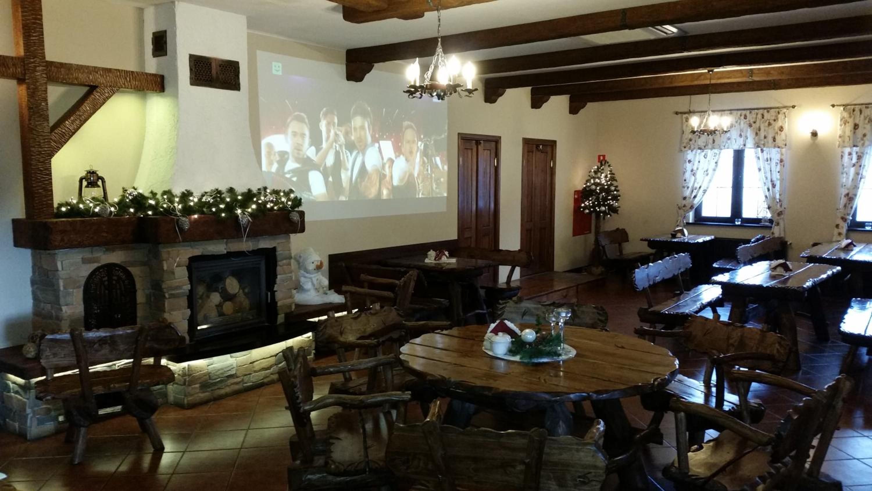 A cozy interior with a fireplace, wooden furniture, and a Christmas tree.
