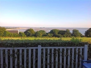 Une vue sur une rivière, avec une clôture en bois au premier plan.