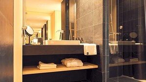 A modern bathroom with a large mirror, a sink, and a shower area. - Hotel Milla Montis (Rio di Pusteria)