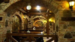 A stone-walled interior with wooden benches and a clock on the ceiling. - Hotel Tukums (Tukums)
