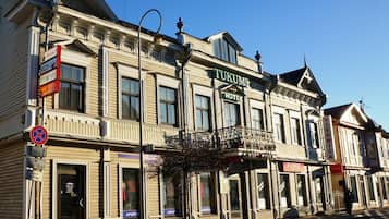 Un bâtiment historique portant une enseigne indiquant « HÔTEL DE TUKUMS » et une autre enseigne indiquant « VIESNICA ».