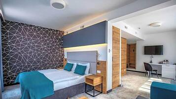 Un dormitorio moderno con cama, mesitas de noche, escritorio y televisor.