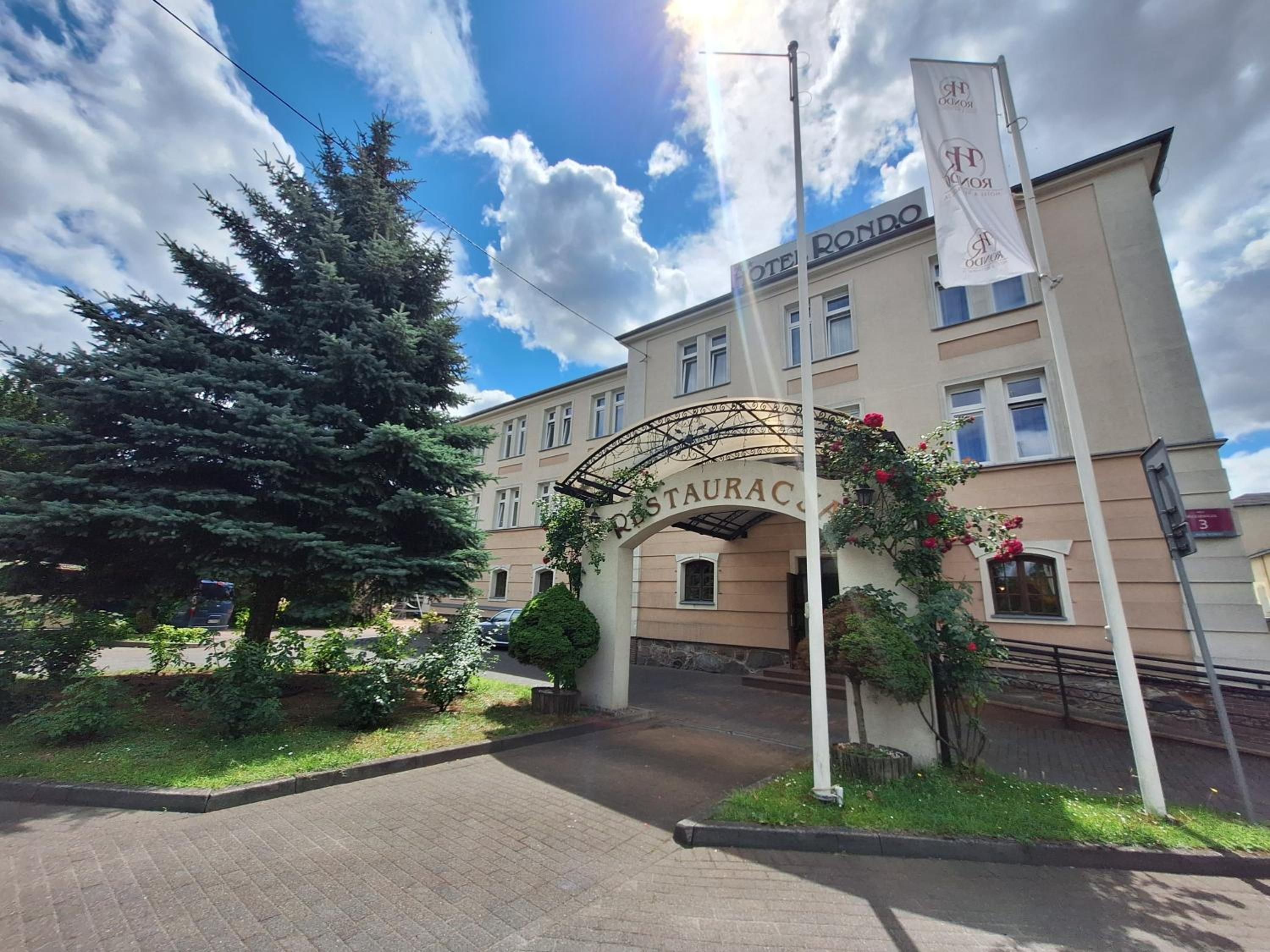 A hotel entrance with a sign reading 'HOTEL RONDO' and a decorative archway.