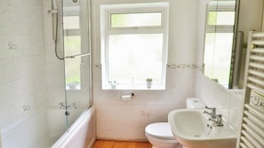 A bathroom with a glass shower enclosure, a toilet, a sink, and a window with a view. - Baltija (Ventnor)