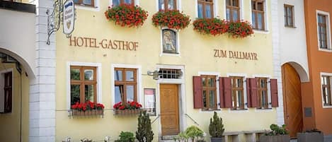 A building with a sign reading 'HOTEL-GASTHOF' and 'ZUM DALLMAYR'.