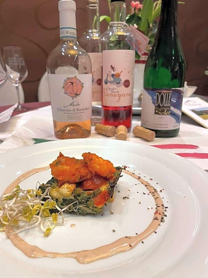 A plate of food with a bottle of wine and a bottle of olive oil on the table.