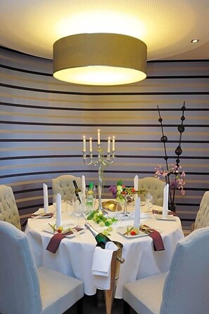 A dining table set with white tablecloth, candles, and a candelabra. - Landhaus Heidekrug (Diekholzen)
