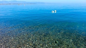 A clear view of a lake with visible underwater rocks and a distant shoreline. - Hotel Poseidon (Corigliano-Rossano)