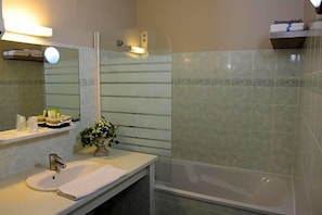Un bagno con lavandino, specchio e doccia.