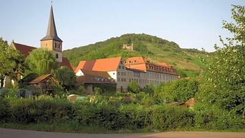 A town with a church, a hilltop castle, and residential buildings with red roofs.