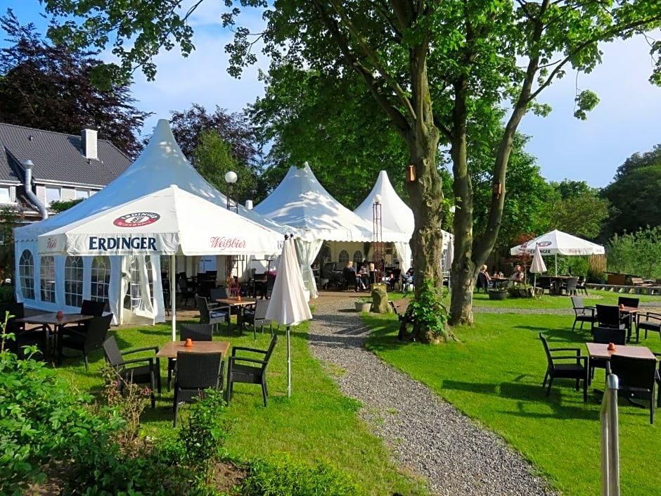 A garden area with outdoor seating, white tents, and a gravel path.
