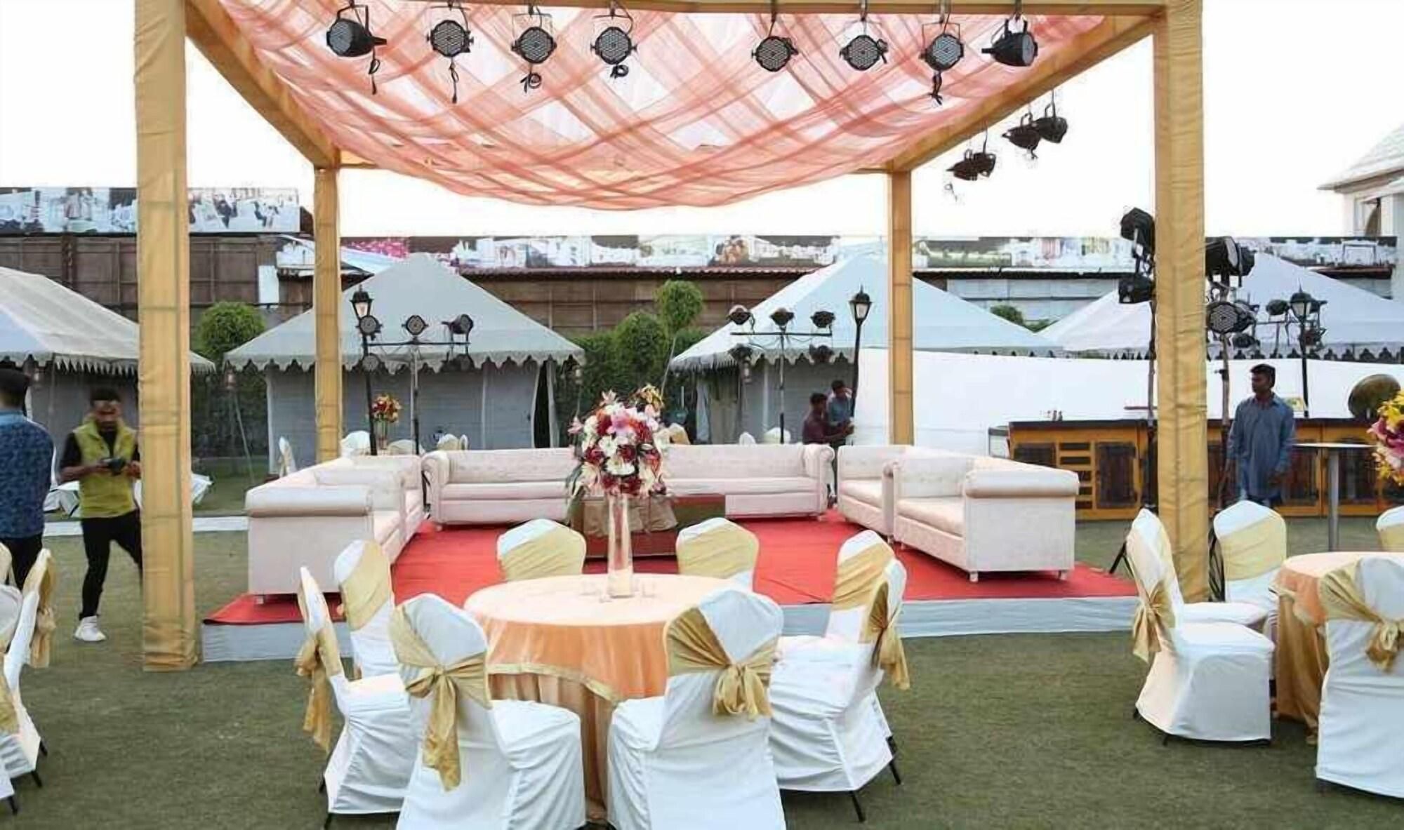 An outdoor event space with a stage, seating, and tables.