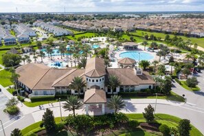 Un barrio residencial con una casa grande que tiene piscina y cancha de tenis.