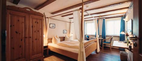 Un dormitorio con cama con dosel, muebles de madera y un armario grande.