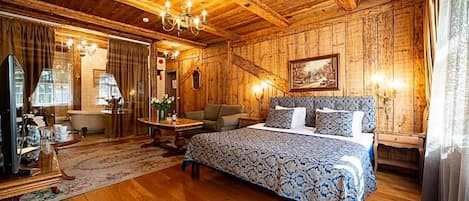 A wooden-finished room with a bed, a desk, and a chair.