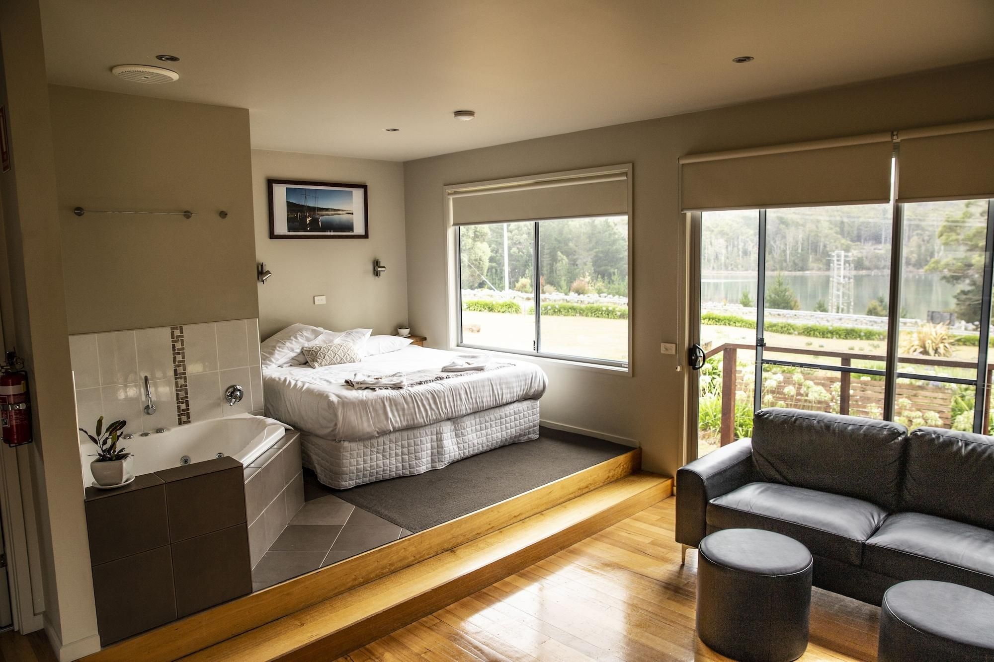 Une chambre à coucher avec un lit, une fenêtre, une salle de bain et une vue sur l’extérieur.