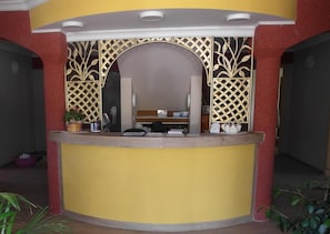 A reception desk with a curved design, a potted plant, and a chair. - Seehotel Bad Kleinen (Bad Kleinen)