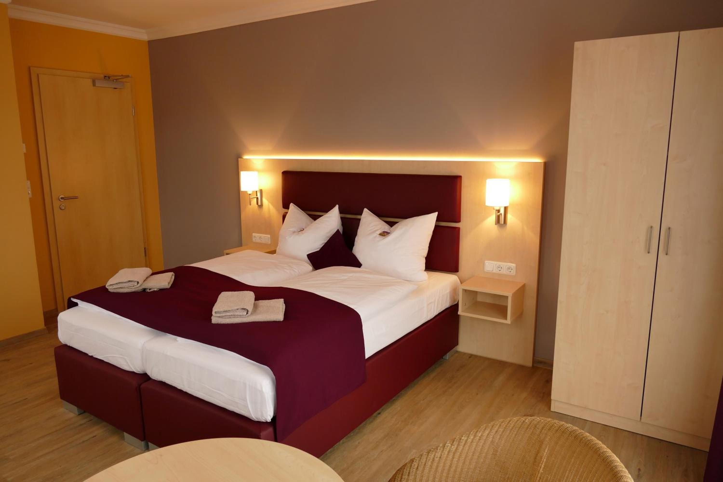 Ein Hotelzimmer mit einem großen Bett, zwei Nachttischen, einem Kleiderschrank und einer Sitzecke.