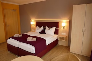 A hotel room with a large bed, two bedside tables, a wardrobe, and a seating area. - Seehotel Bad Kleinen (Bad Kleinen)