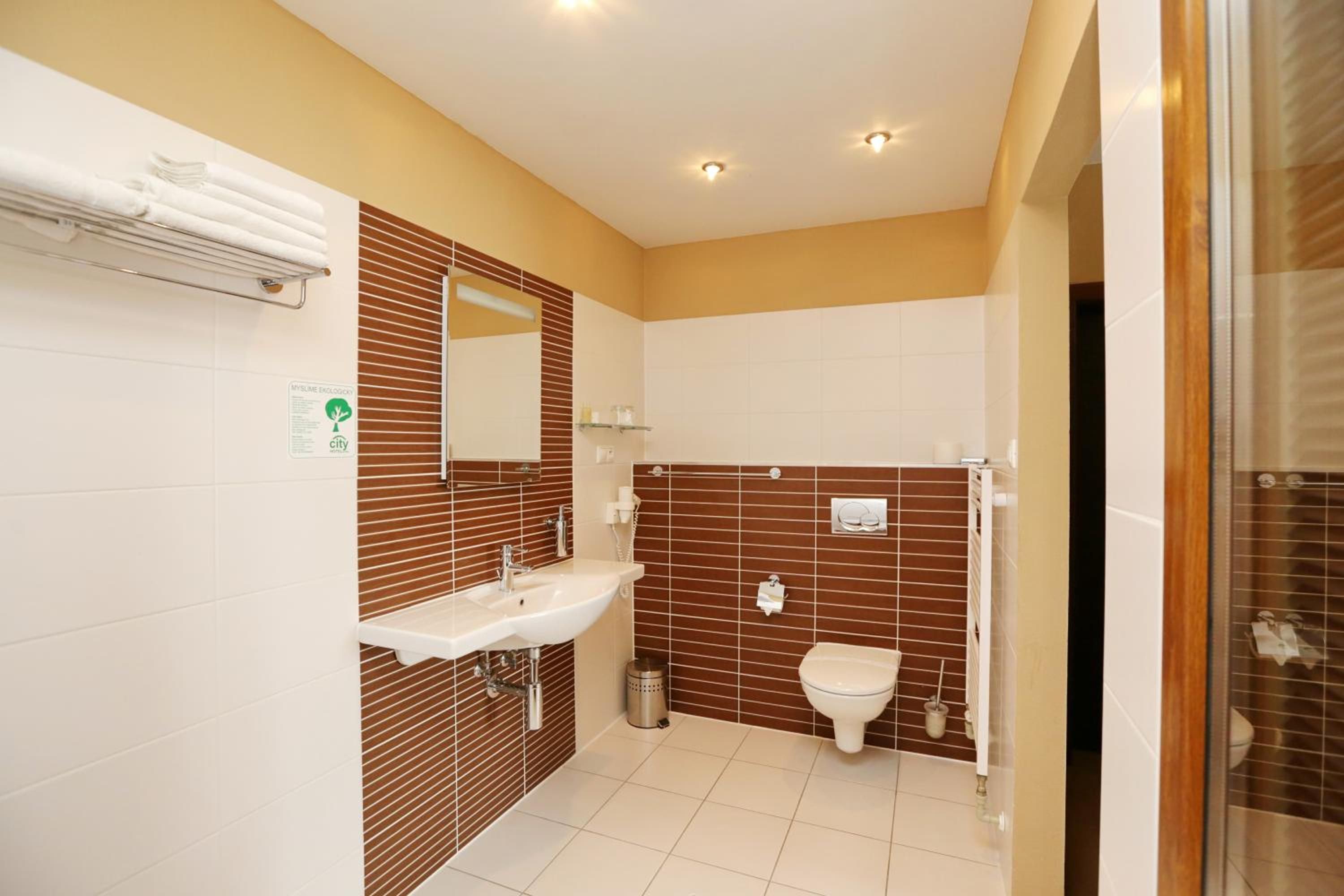 A modern bathroom with a sink, mirror, and toilet.
