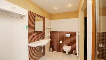 A modern bathroom with a sink, mirror, and toilet.
