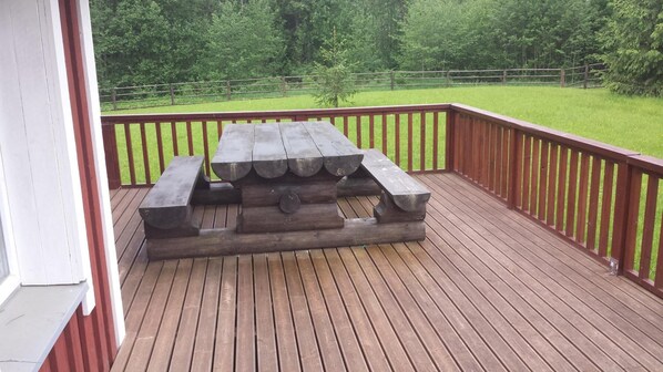 A wooden deck with a picnic table.