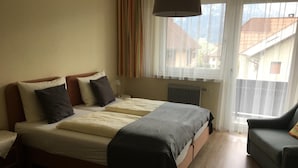 Una cama doble con estructura de madera, una mesita de noche y una silla.