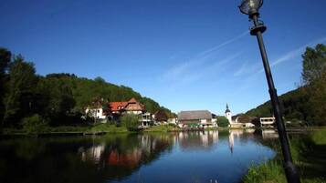 Ein ruhiger See mit einer Kirche und Wohnhäusern am gegenüberliegenden Ufer.