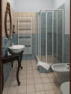 A bathroom with a white sink, a mirror, a shower enclosure, and a toilet. - Hotel Na Kafkovv (Ostrava)