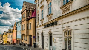 A street with historic buildings, including a museum with a classical facade. - Hotel Restaurant Pod Ka Tany (Krupka)
