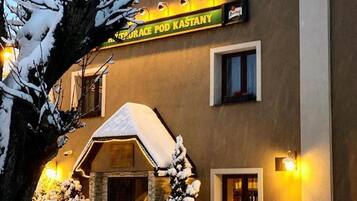 Ein Gebäude mit einem Schild, auf dem 'RESTAURACE POD KASTANY' steht, das ein Restaurant kennzeichnet.