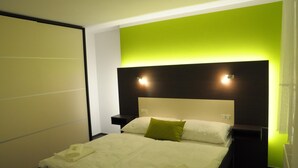 A hotel room with a bed, a nightstand, and a wall with a green accent. - Hotel Kaskada (Ledeč nad Sázavou)