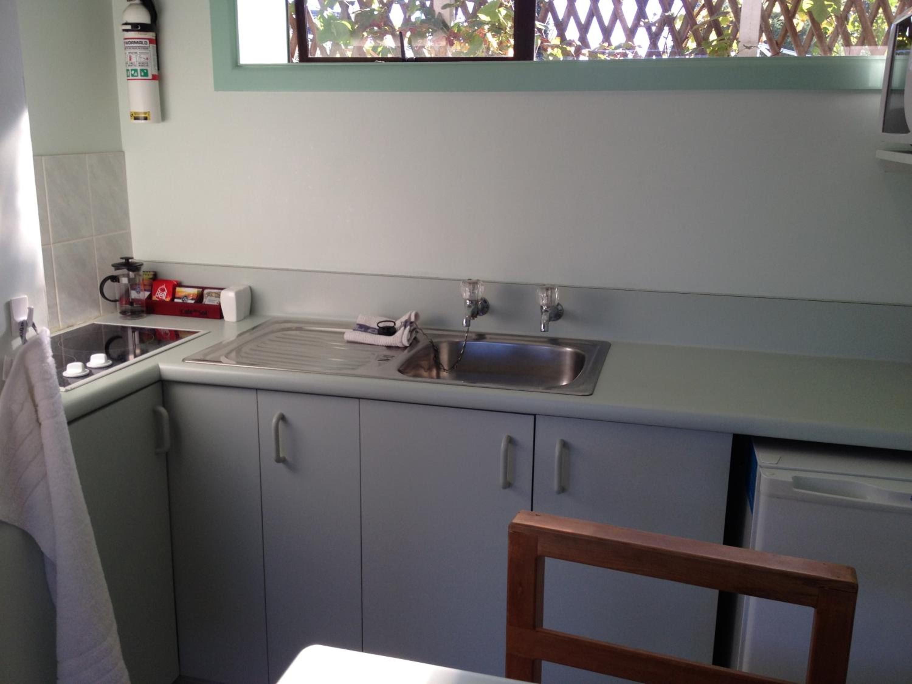 A kitchen with a sink, stove, and cabinets.