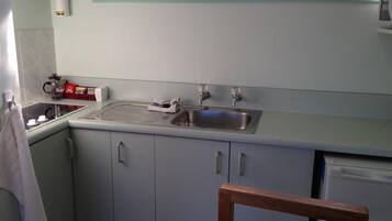 A kitchen with a sink, stove, and cabinets.