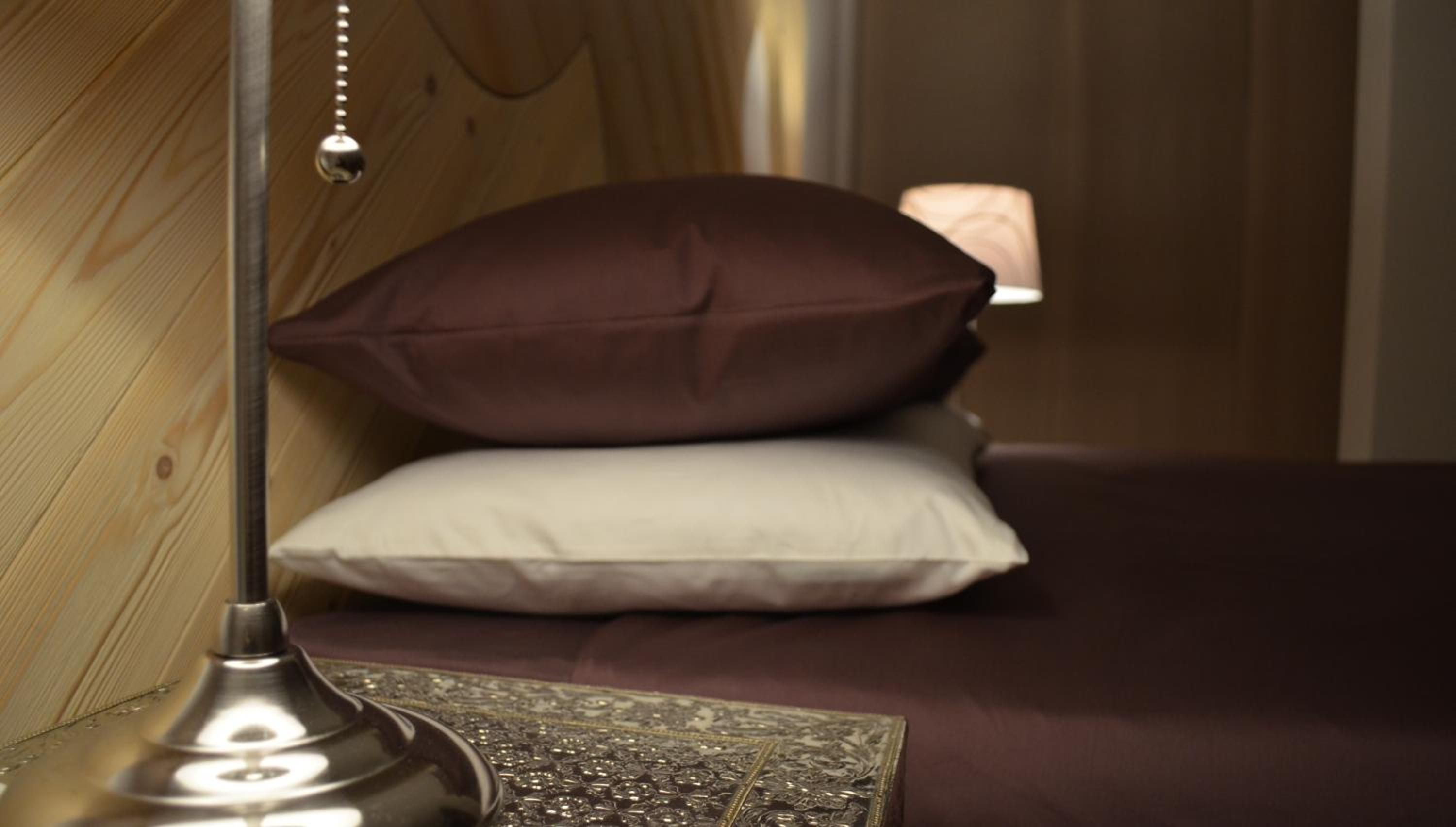 Un lit avec deux oreillers et une lampe de chevet.