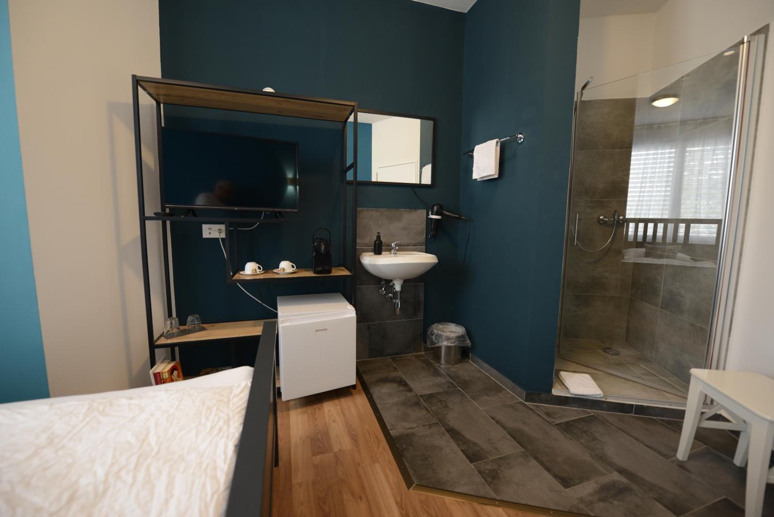 A modern bathroom with a shower, a sink, and a mirror.