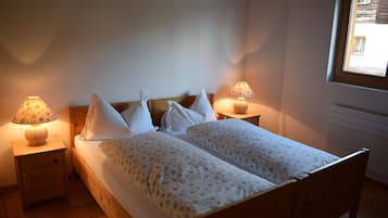 Ein Schlafzimmer mit einem Holzbett, zwei Nachttischlampen und einem Fenster.