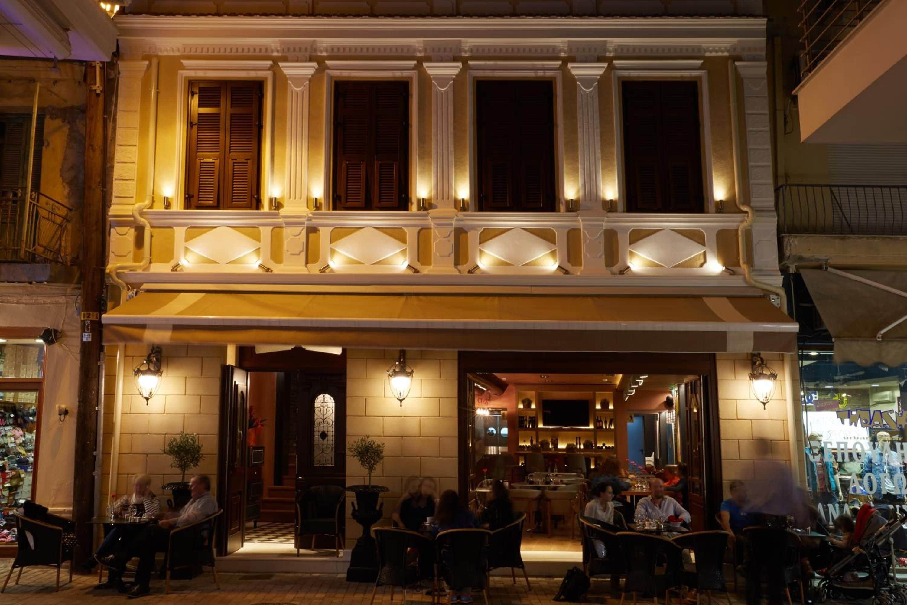 Een gebouw met twee verdiepingen, een balkon, een terras en een restaurantinrichting.