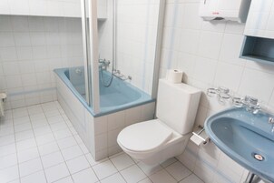 Un baño con bañera, inodoro y lavabo.