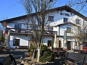 A hotel with a white exterior, multiple windows, and a balcony. - Hotel Sjesta (Mikołów)