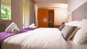 A hotel room with a bed, pillows, a nightstand, a wardrobe, and a window with curtains. - Antikyra Beach Hotel (Distomo-Arachova-Antikyra)