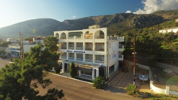 A multi-story hotel with balconies and a view of the surrounding landscape.