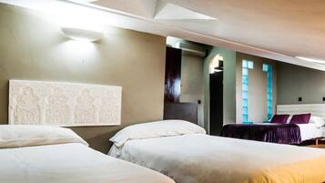 Habitación de hotel con dos camas, un escritorio, una silla y un espejo.
